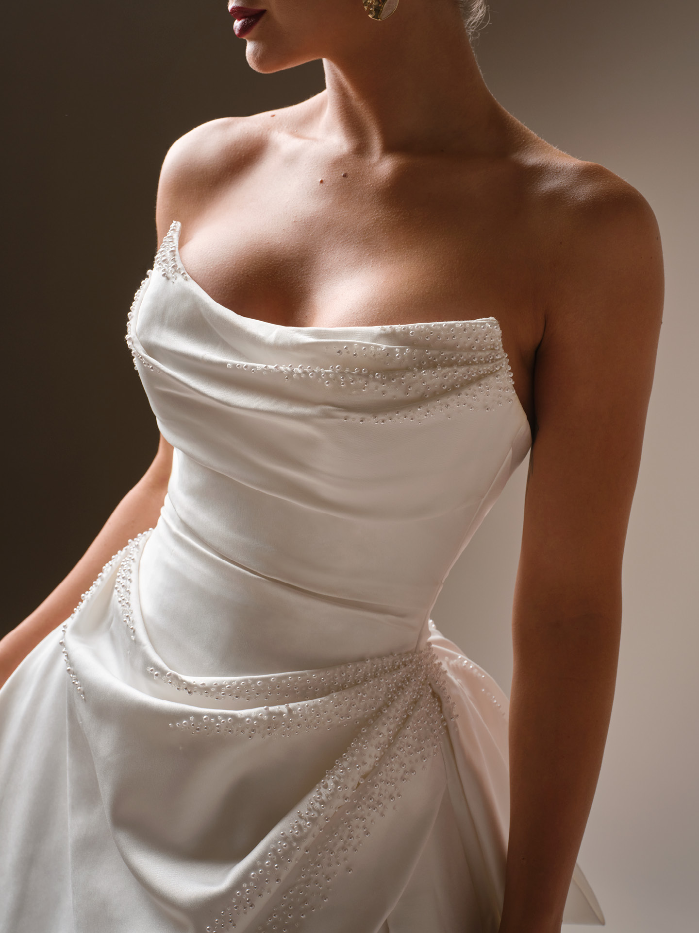 Sottero and Midgley Kincaid wedding dress close-up of softly draped satin neckline with delicate beaded embellishments and structured bodice, highlighting a sleek and sophisticated silhouette