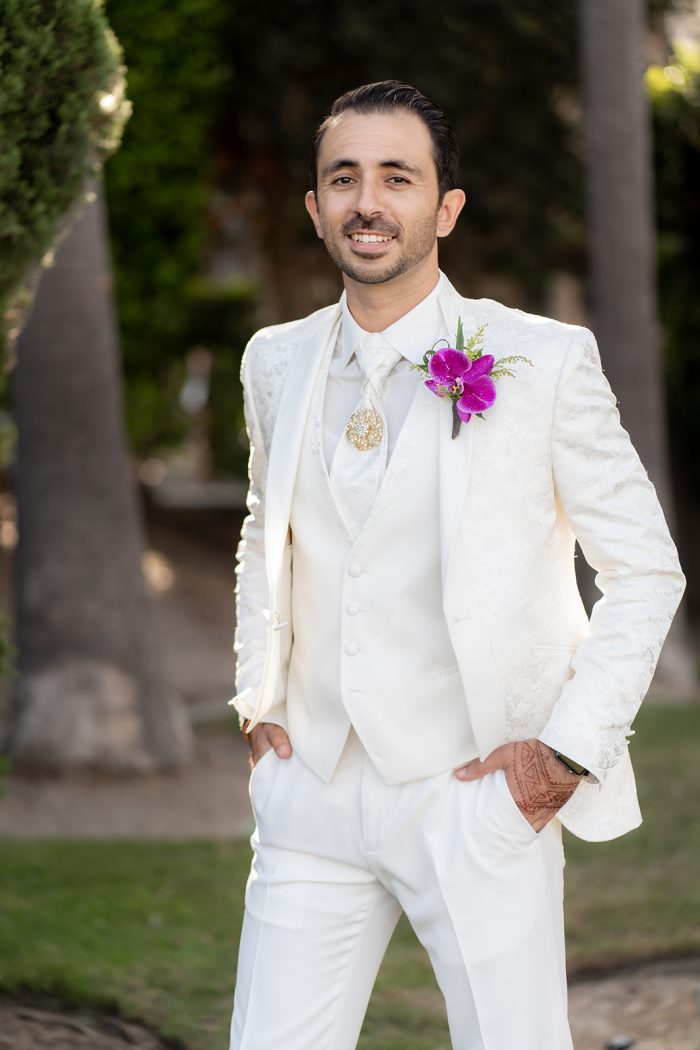 Groom In White Suit With Pink Flower