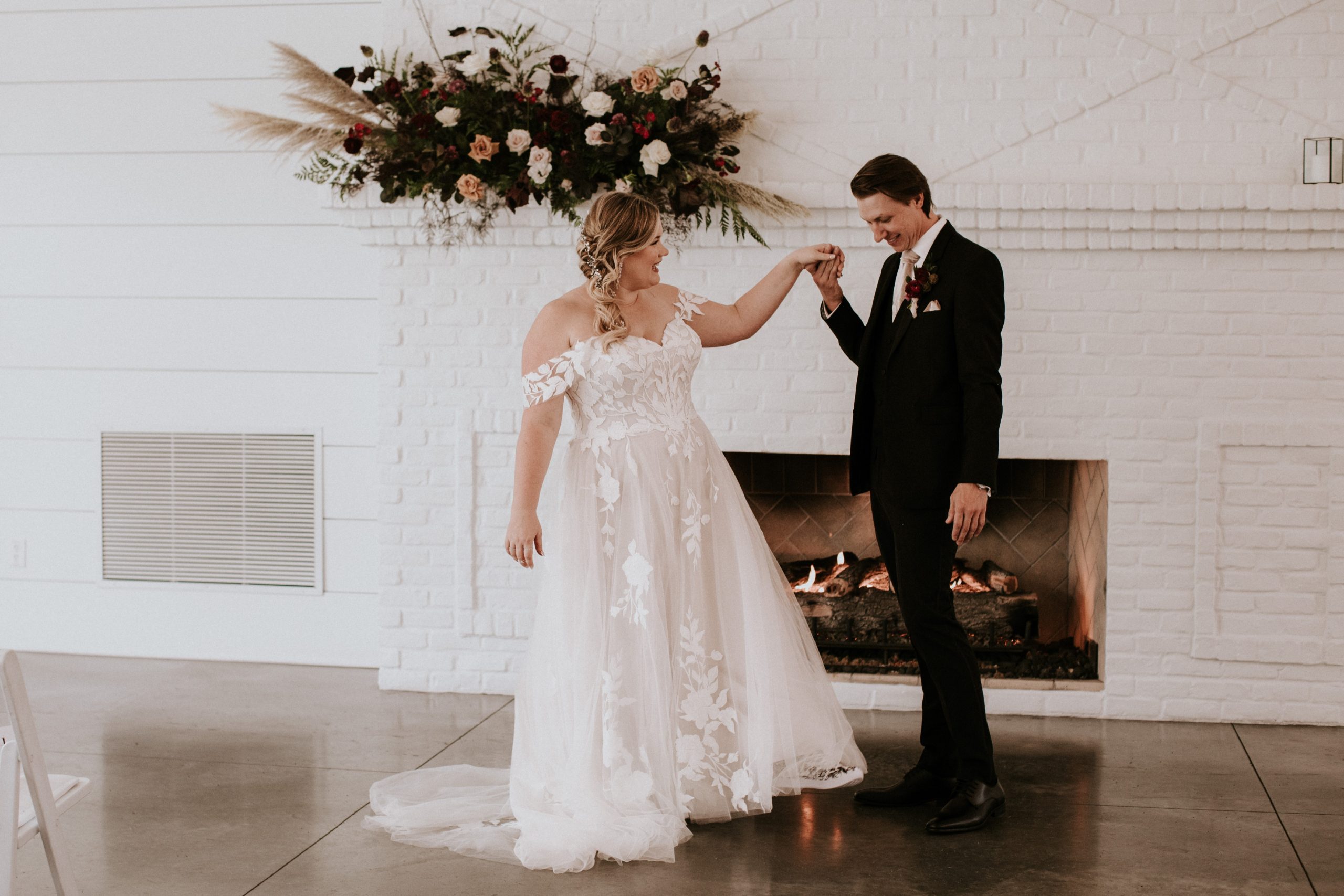 Bride In Modern A-Line Wedding Dress Called Hattie Lane Lynette By Rebecca Ingram With Groom In White Room With Flowers