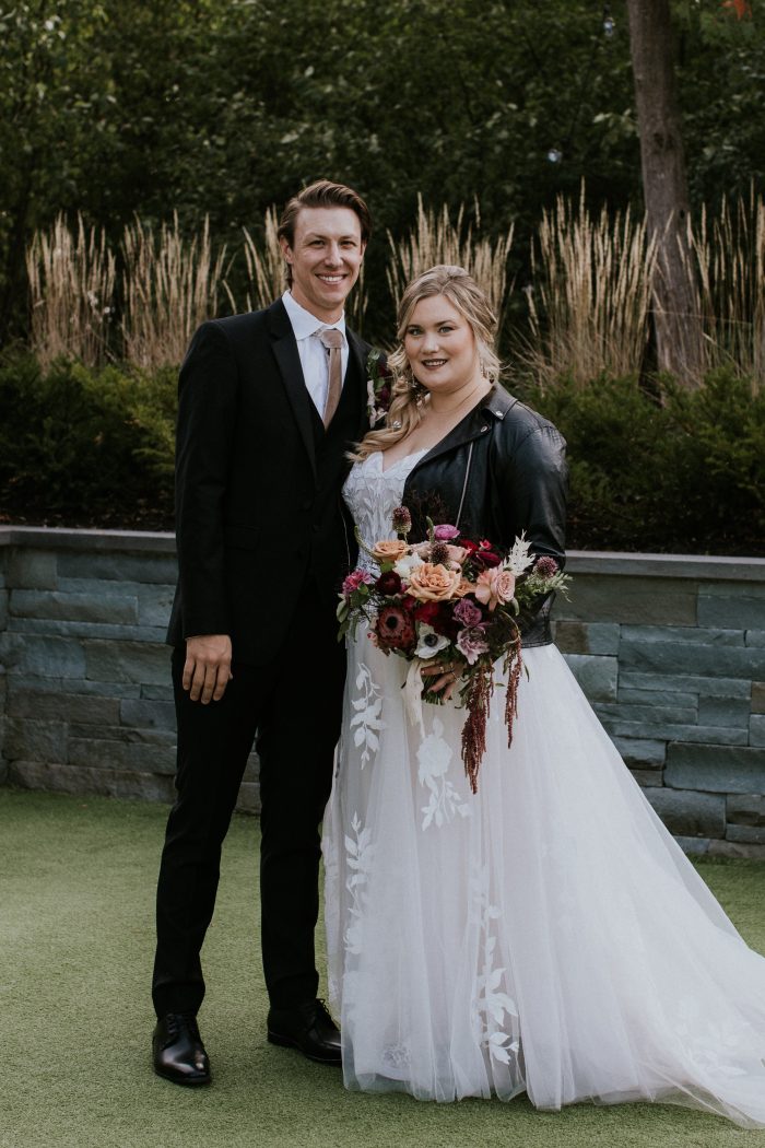 Bride In Black Leather Jacket With Lace Plus Size Wedding Dress Called Hattie Lane Lynette By Rebecca Ingram With Groom In Black Suit