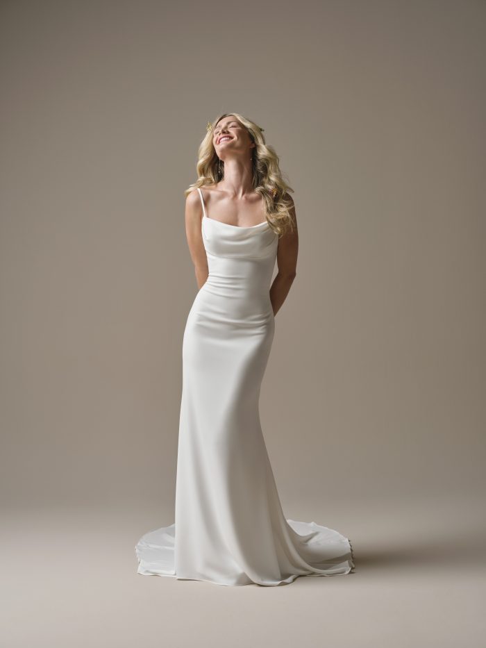 Front view of the Rebecca Ingram Brenda sheath wedding dress featuring a draped scoop neckline, spaghetti straps, and a sleek fitted silhouette.