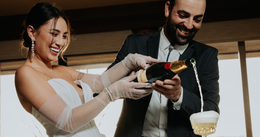 Bride and groom pouring champaign to stay stress-free