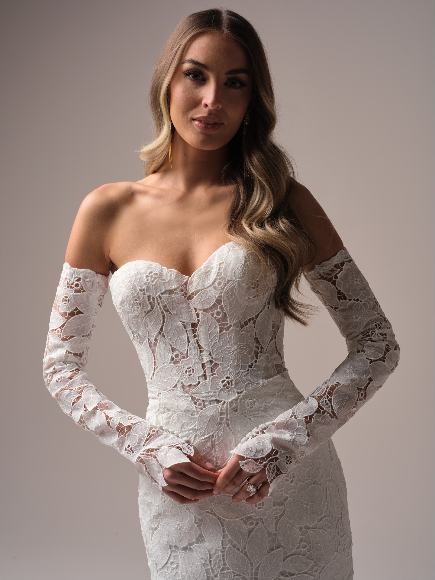 Close-up of Dakota by Maggie Sottero featuring unembellished lace, illusion bodice with exposed boning, off-the-shoulder lace sleeves, and sweetheart neckline.