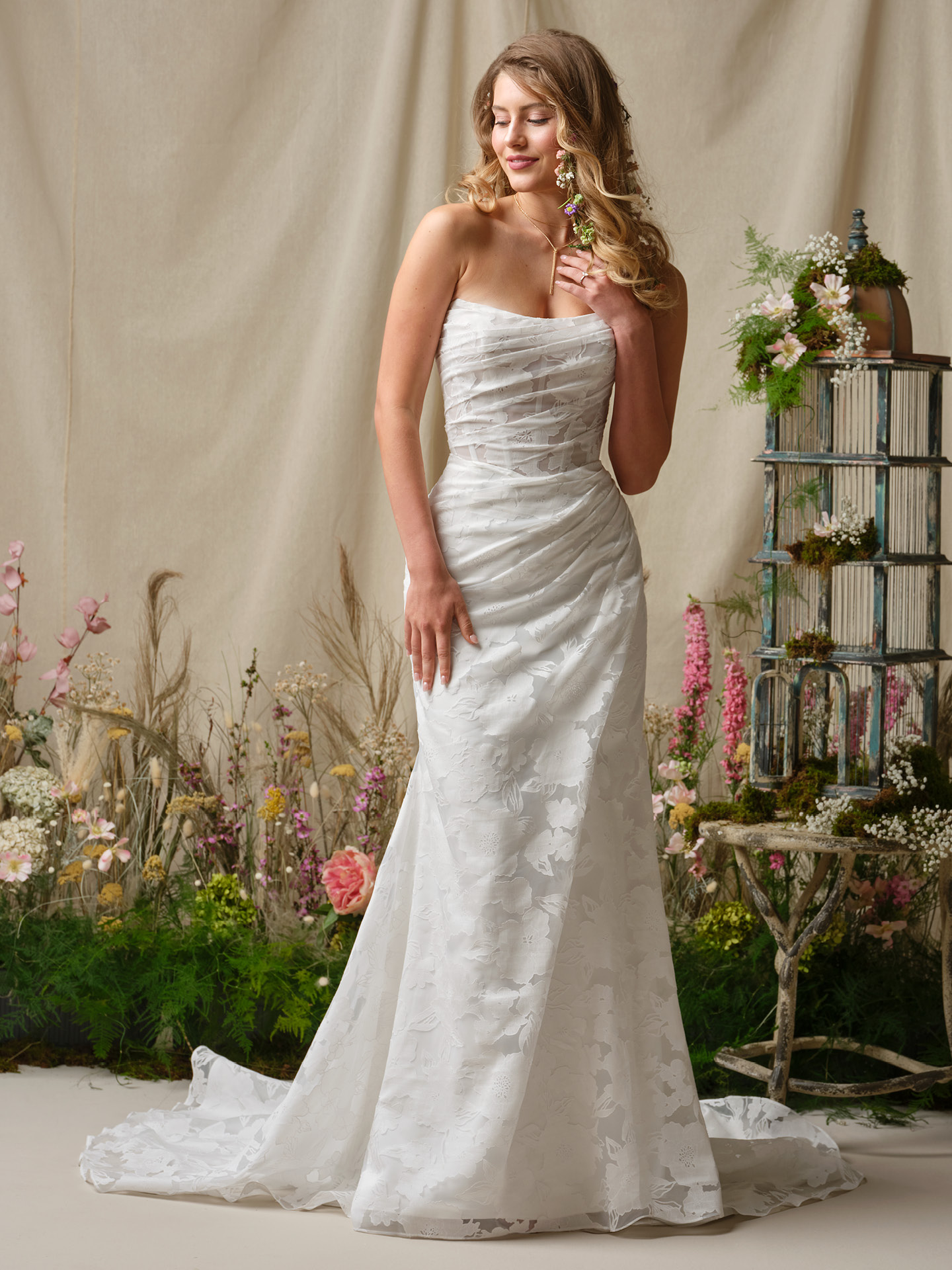 Bride wearing Kendall by Rebecca Ingram, a strapless printed organza sheath wedding dress with ruched bodice, soft sweetheart neckline, and fitted silhouette.