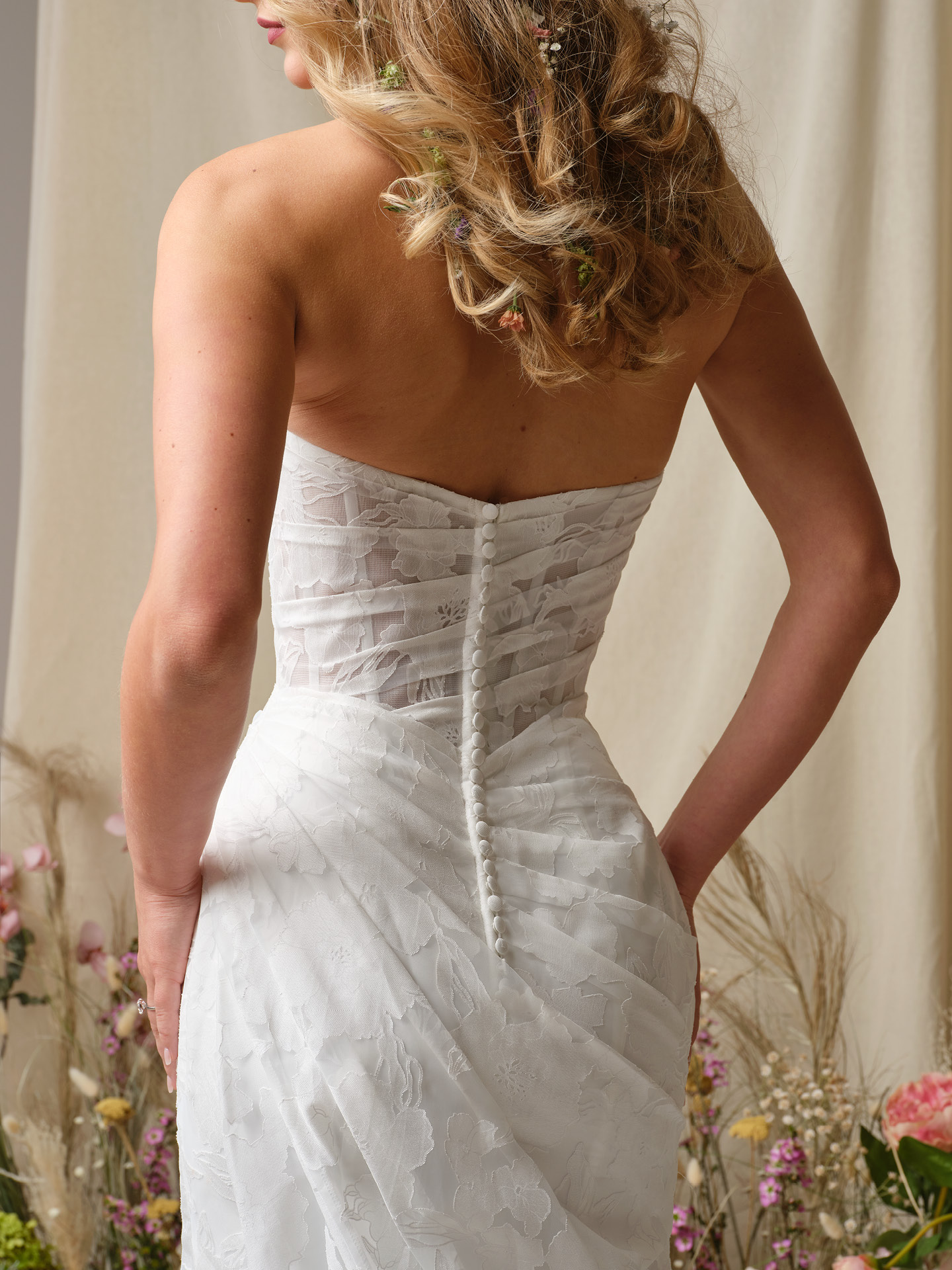 Back view of Kendall by Rebecca Ingram featuring ruched printed organza, covered button closure, and fitted sheath skirt with soft train.