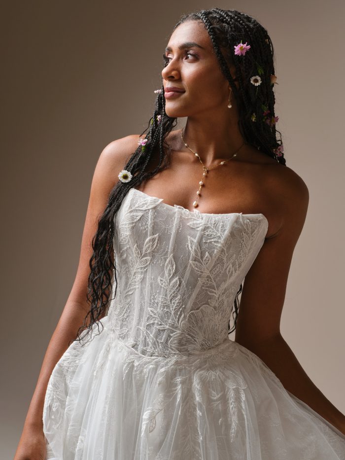 Close-up of the Rebecca Ingram Lisa wedding dress highlighting the illusion lace bodice with exposed boning, cat-eye neckline, and soft basque waist.
