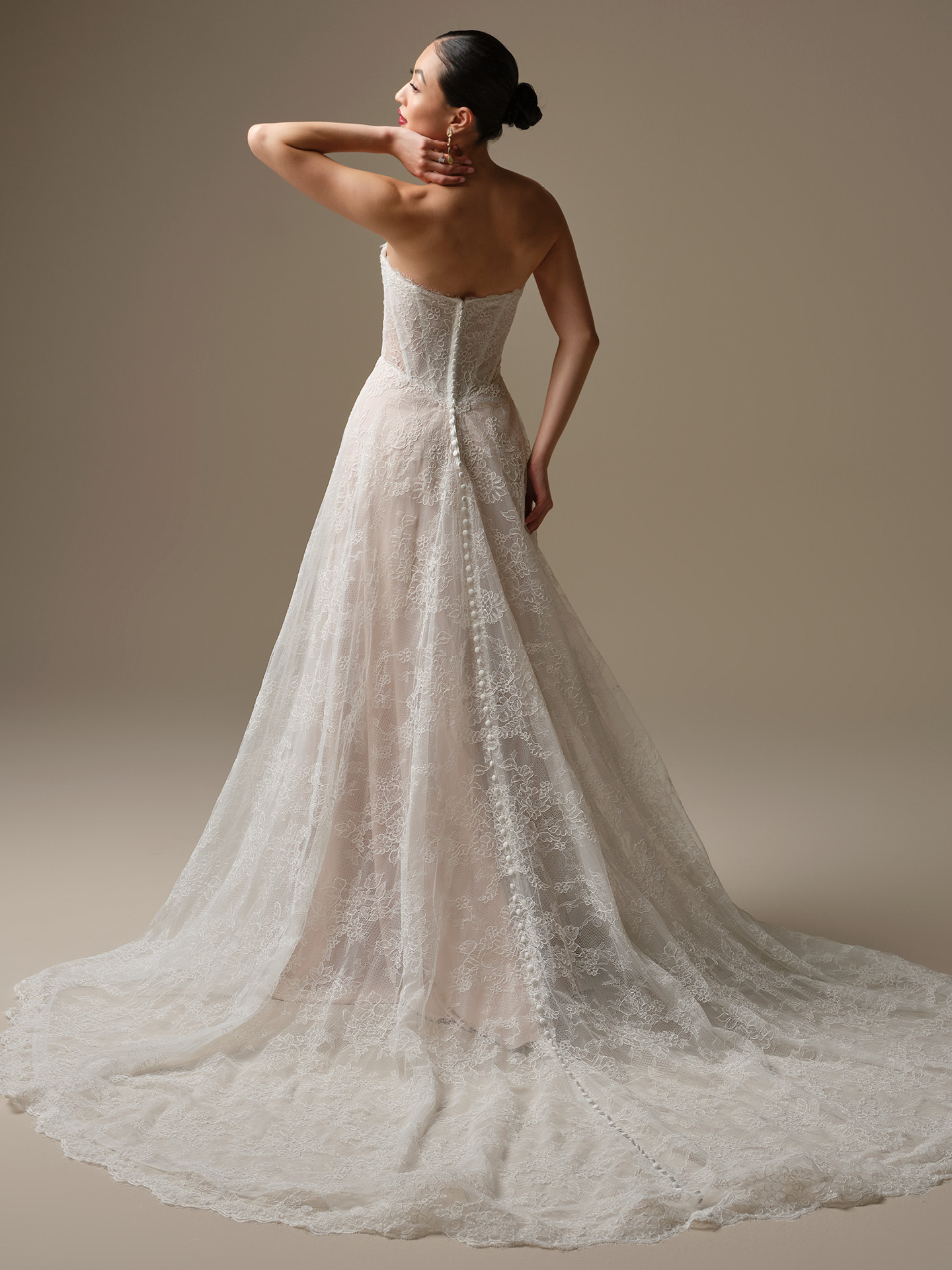 Back view of Granger by Sottero and Midgley featuring strapless Chantilly lace bodice, covered button closure, and extended illusion lace train.