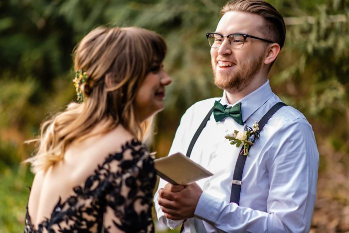 Bride wearing Zander by Sottero and Midgley while her husband reads his wedding vows