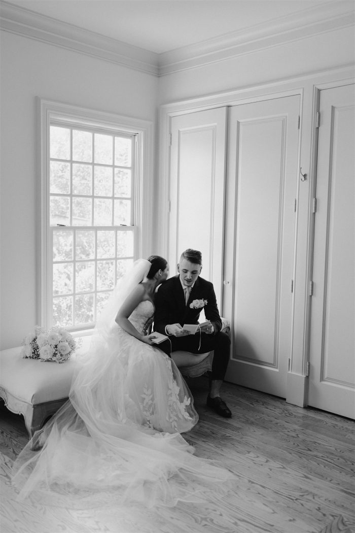 Bride wearing Hattie by Rebecca Ingram reading wedding vows with her husband