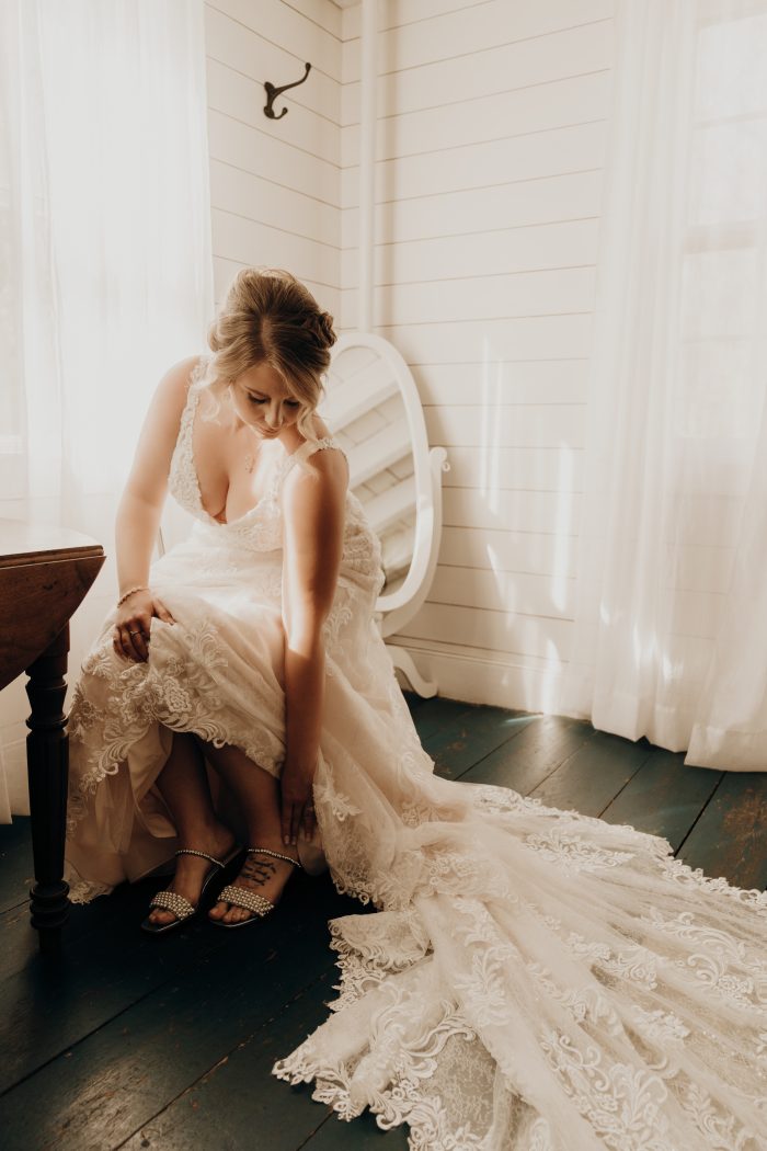 Bride wearing her wedding shoes in Johanna gown by Maggie Sottero