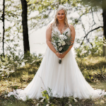 Bride Holding Flower Bouquet in a Field Wearing Lorraine by Rebecca Ingram