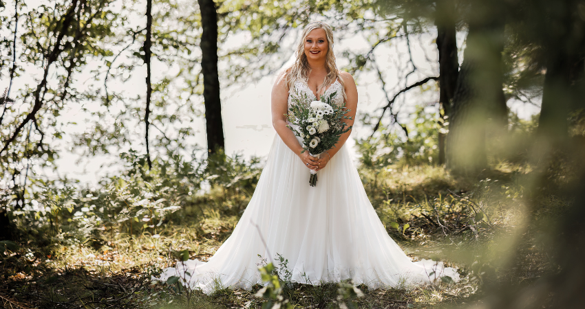 Bride Holding Flower Bouquet in a Field Wearing Lorraine by Rebecca Ingram