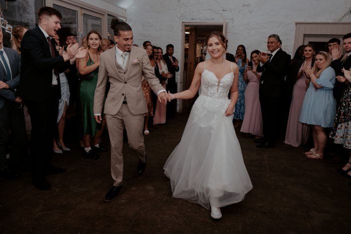 Bride wearing converse as her wedding shoes in Stevie wedding dress by Maggie Sottero