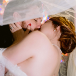 Bride and Groom Kissing Under Veil