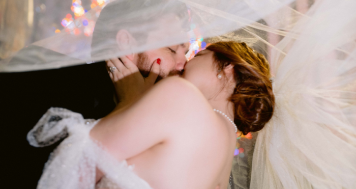 Bride and Groom Kissing Under Veil