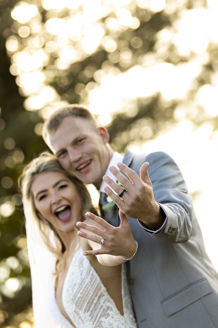 Bride wearing Bracken gown by Sottero and Midgely along with her and her husband's wedding and engagement rings 