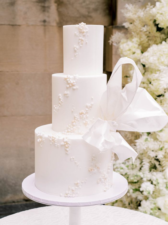 White wedding cake with pearls and oversized bow