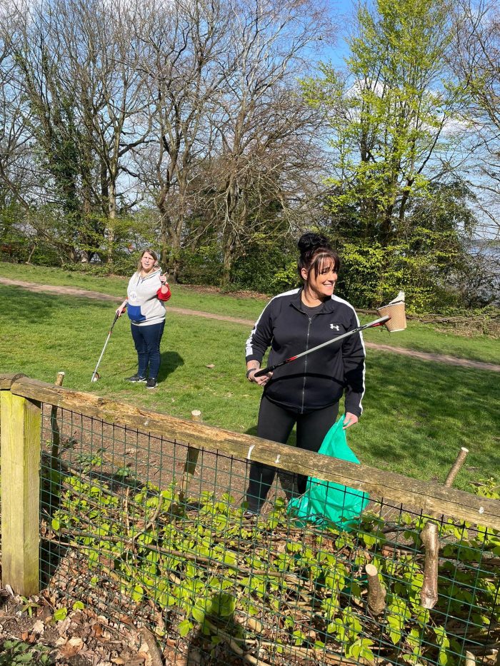 Two Maggie Sottero team members picking up trash in support of habitat preservation