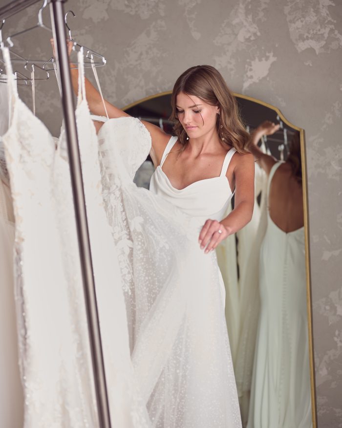 Bride looking through Maggie Sottero wedding gowns during Cheer for Charity