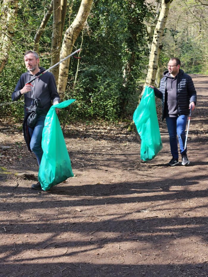 Two Maggie Sottero team members picking up trash