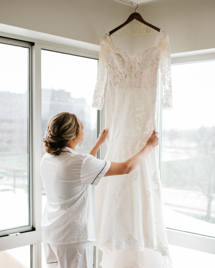 Bride with a positive body image holding up Fiona by Maggie Sottero