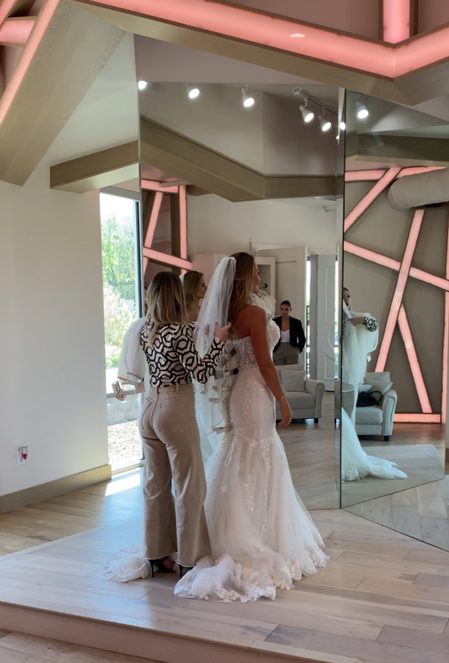 Stylist showing bride a wedding dress at her bridal appointment