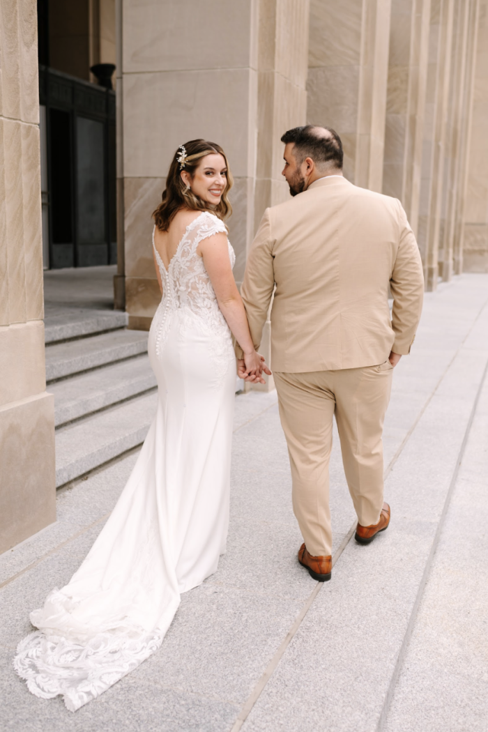 Bride wearing Anson by Sottero and Midgley while holding hands with her husband