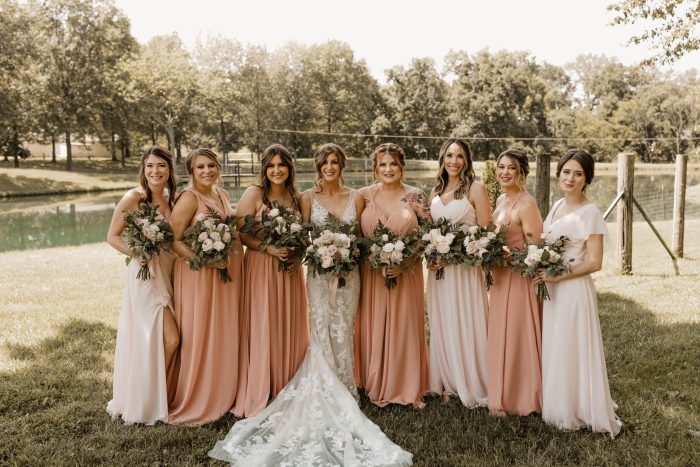 Bride wearing Greenley wedding gown by Maggie Sottero surrounded by her bridesmaids