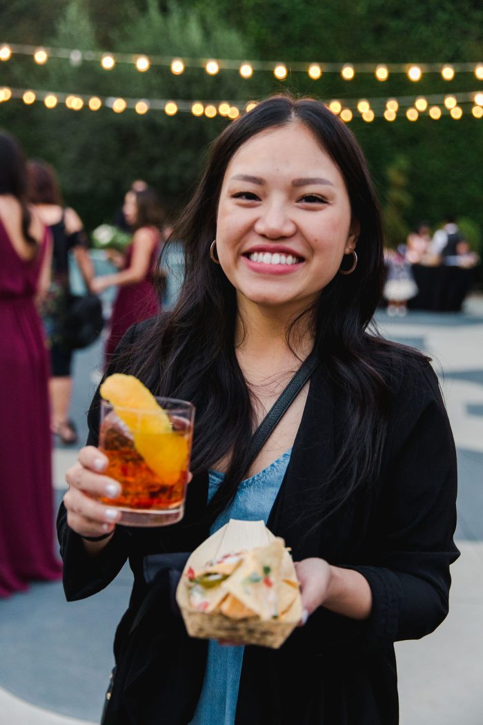 A girl eating and drinking at an engagement party