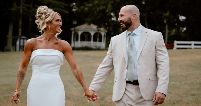 Bride wearing a wedding dress by Maggie Sottero holding hands with her husband