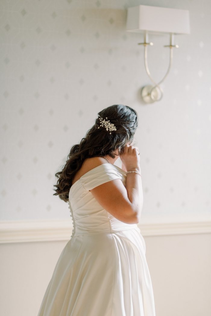 Bride wearing a bridesmaid's earrings as her something borrowed wedding tradition