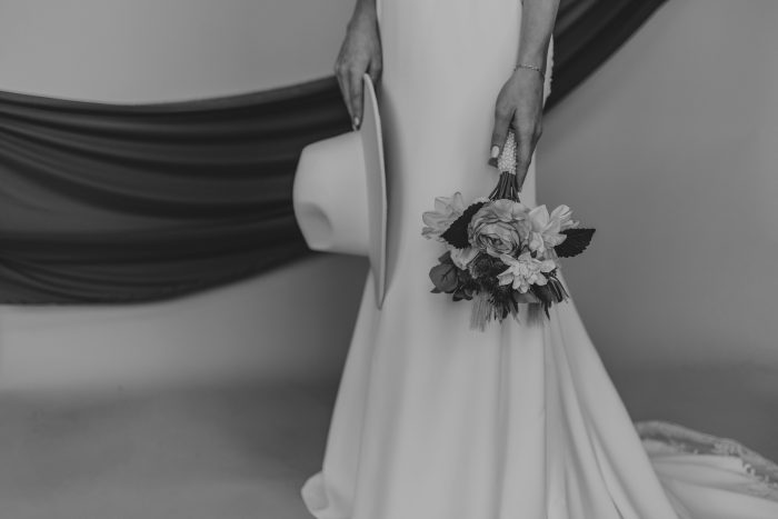 Bride wearing Bellarose retro wedding dress by Rebecca Ingram holding a mini bouquet