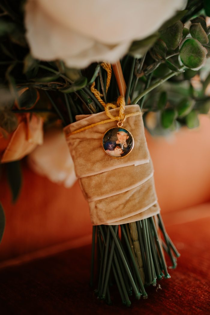 Antique photo hung on bride's bouquet as a wedding tradition