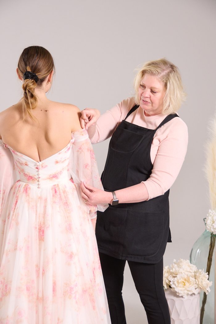 Seamstress doing wedding dress alterations on a bride