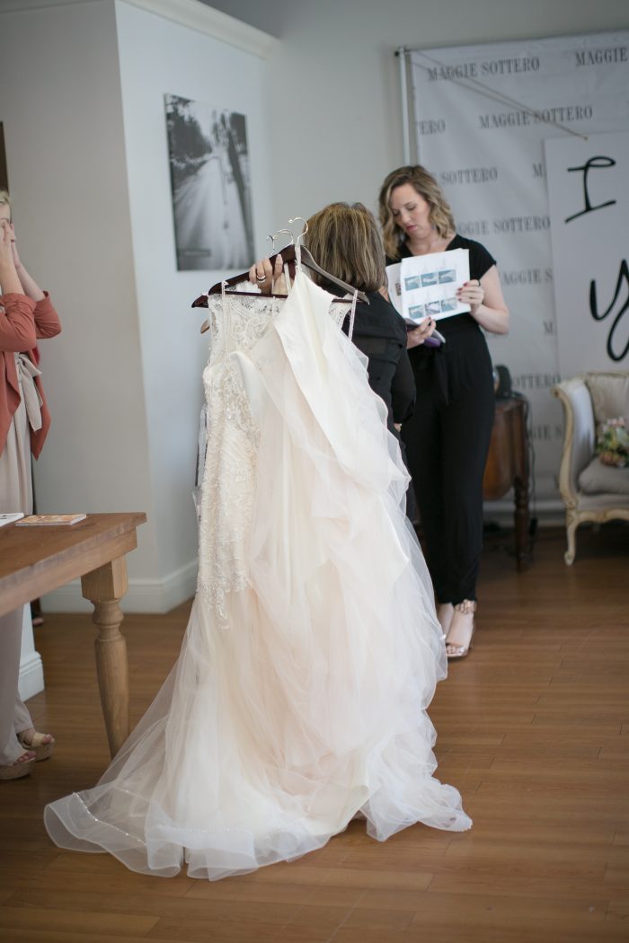 Bridal stylist choosing gowns at a bridal appointment