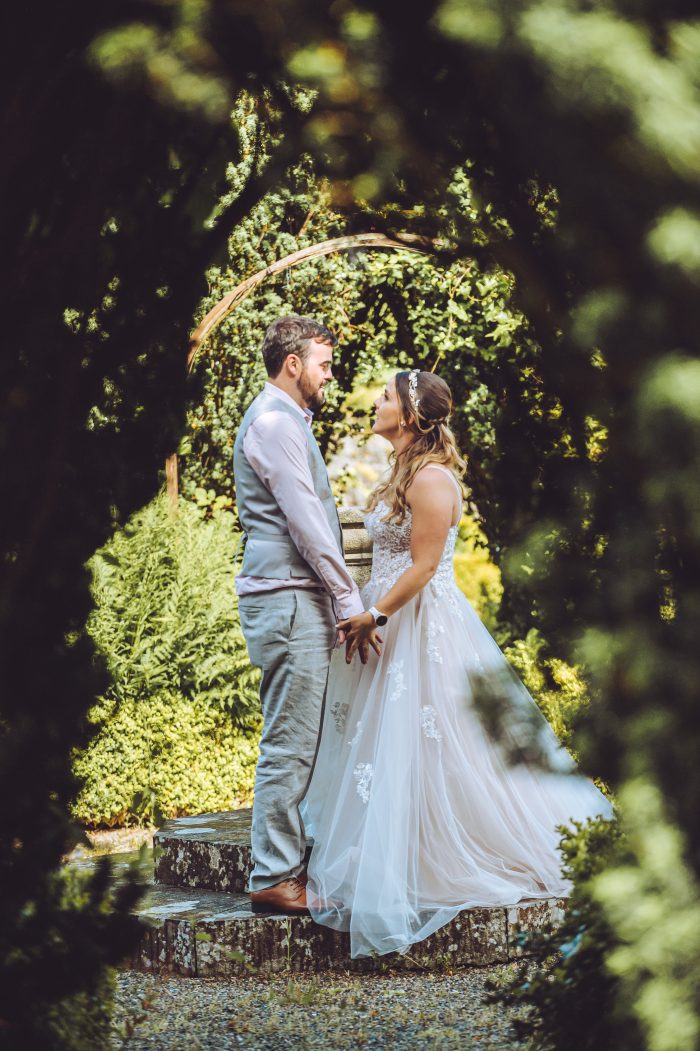 Bride wearing Marisol wedding dress by Rebecca Ingram kissing her husband during their garden party wedding