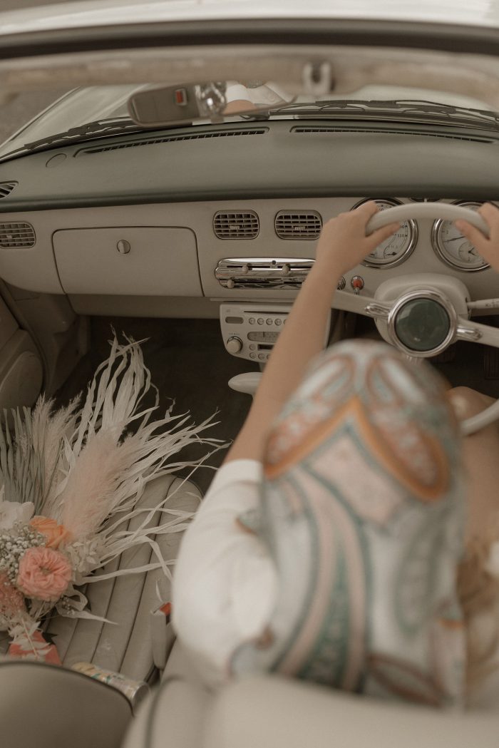 Bride driving a retro car at her wedding