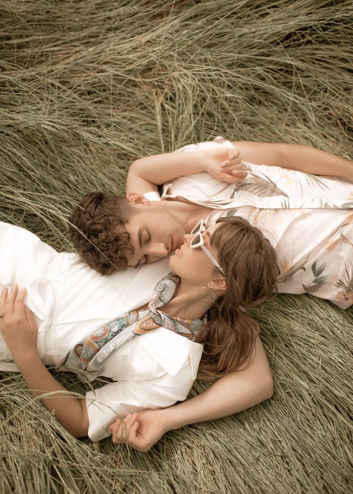 Couple lying in the grass at their retro wedding