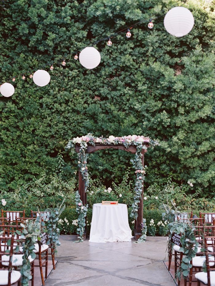 An outdoor wedding venue with green, white, and brown decor