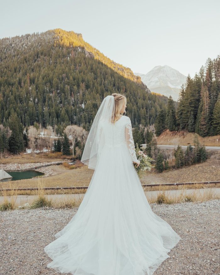 Bride wearing Iris Leigh by Rebecca Ingram looking at the mountains at her outdoor wedding
