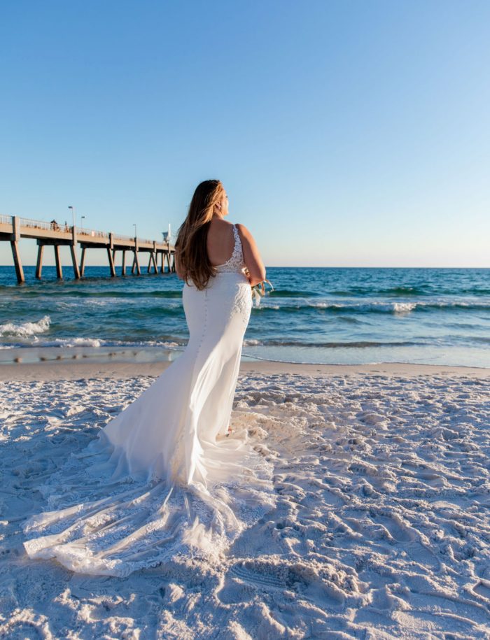 Bride wearing Johanna Lane by Maggie Sottero looking over the water at her beach outdoor wedding