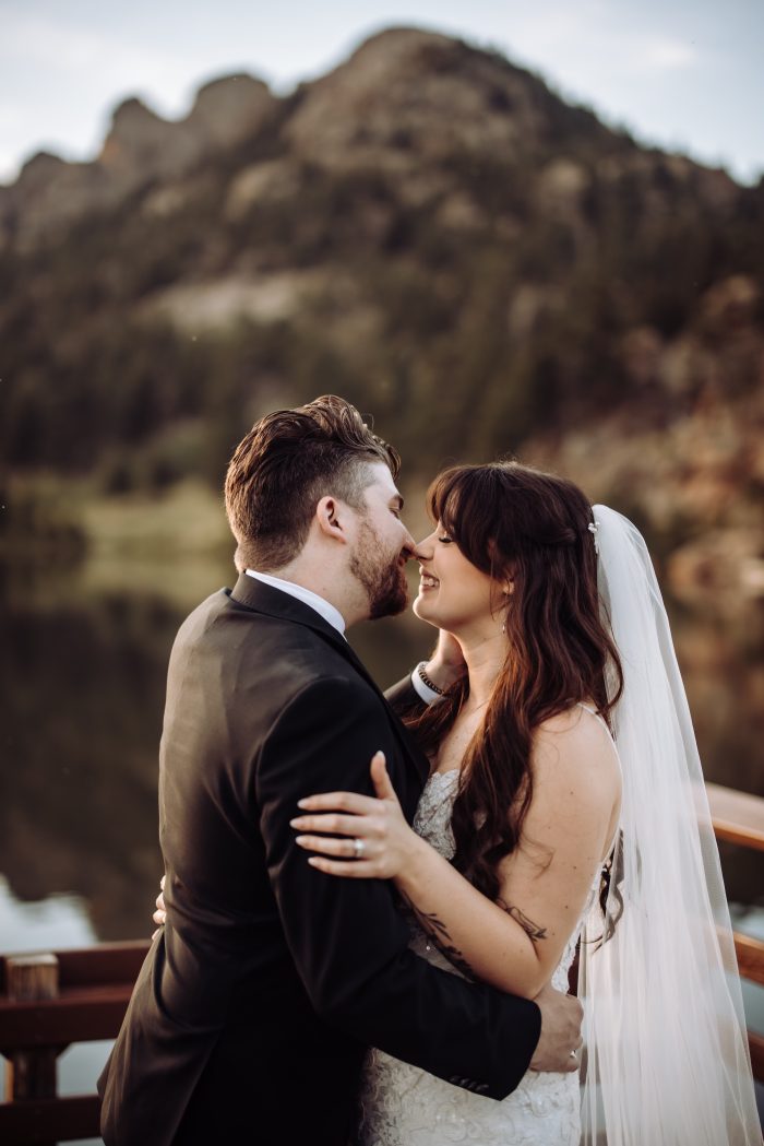 Bride wearing Tuscany Royale by Maggie Sottero kissing her husband at their outdoor wedding