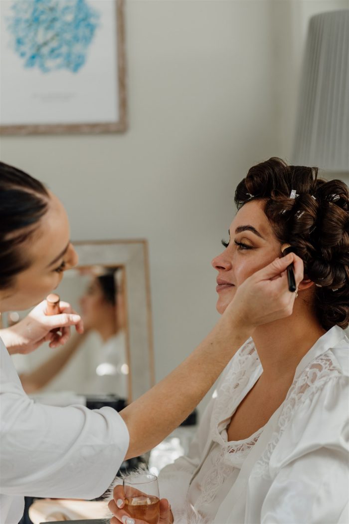 Bride getting her makeup done before her ceremony