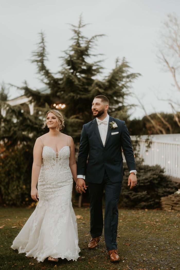 Bride wearing Fiona by Maggie Sottero holding hands with her husband to stay stress-free