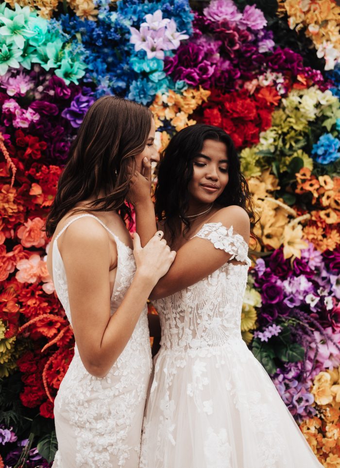 Colorful floral backdrop for LGBTQ+ wedding ideas with bride wearing Harlem by Maggie Sottero