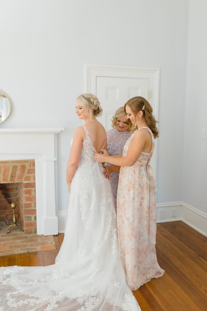 Bride wearing Johanna being zipped up by her bridesmaids staying stress-free