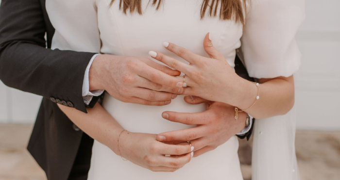 Bride exchanging rings with her husband while wearing modest wedding gown Kashlynn by Maggie Sottero