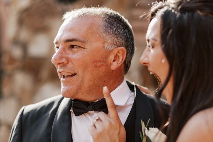 Father of the bride with a kiss on his cheek