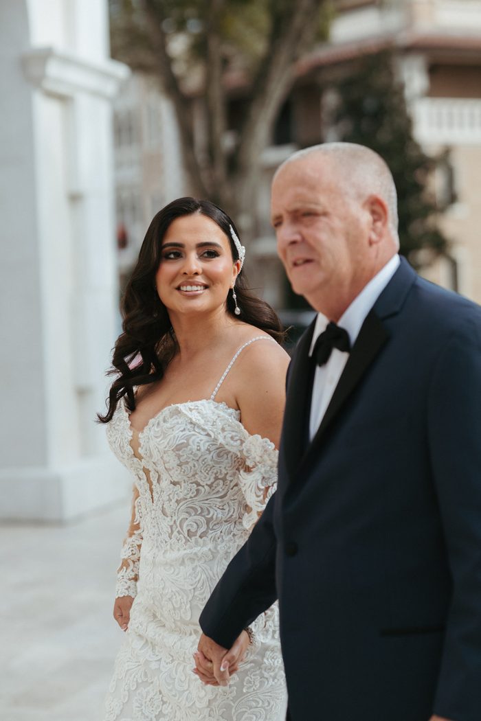 Girl wearing Fiona by Maggie Sottero holding hands with her dad