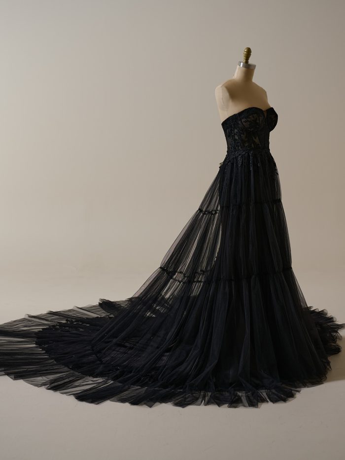 Strapless black tulle wedding dress with a tiered detachable overskirt and flowing train, perfect for a bold, modern bridal statement.